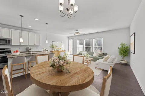 a kitchen with kitchen island granite countertop a refrigerator a stove a sink a dining table and chairs with wooden floor