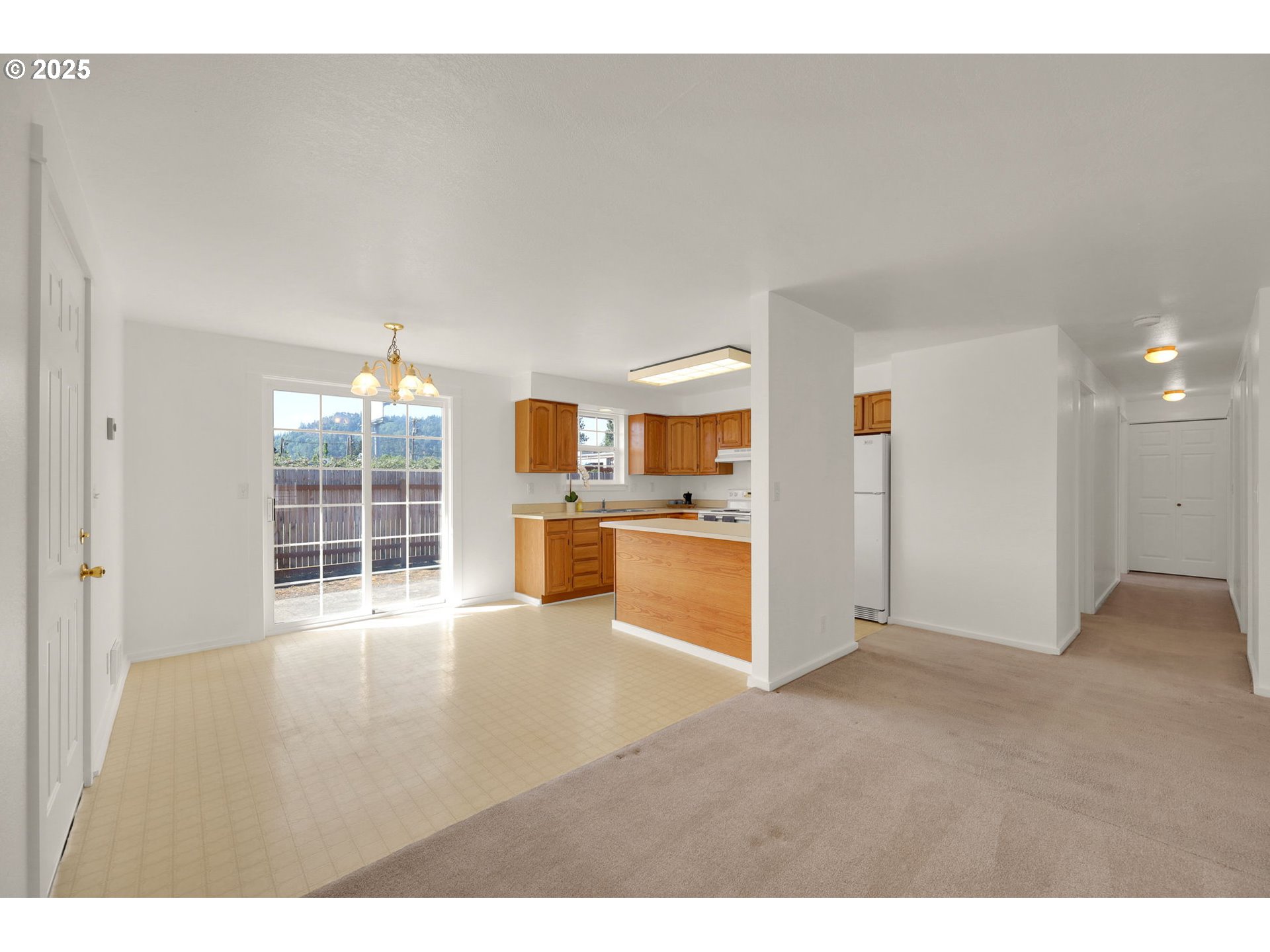 176 19th Street Springfield, OR 97477 - Photo 10 of 35 a view of an empty room with kitchen view and a window