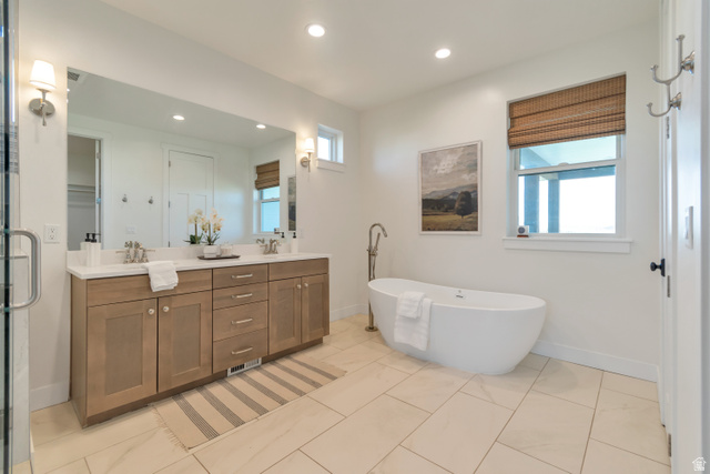 1820 West Farmhouse Flats Road Peoa, UT 84061 - Photo 25 of 79 Spacious bathroom featuring a freestanding soaking tub, dual vanity with light-toned cabinetry, a large wall-mounted mirror, and tile flooring