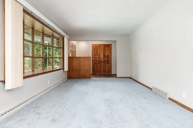 en empty room with windows and chandelier fan