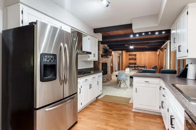 a kitchen with granite countertop white cabinets and white appliances