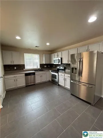 a kitchen with granite countertop stainless steel appliances and white cabinets