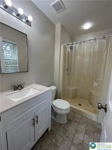 a bathroom with a sink toilet a mirror and shower
