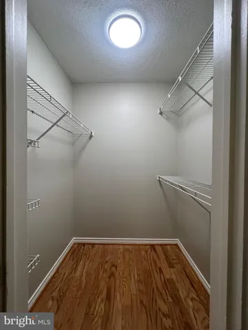 a view of a room with wooden floor and fan