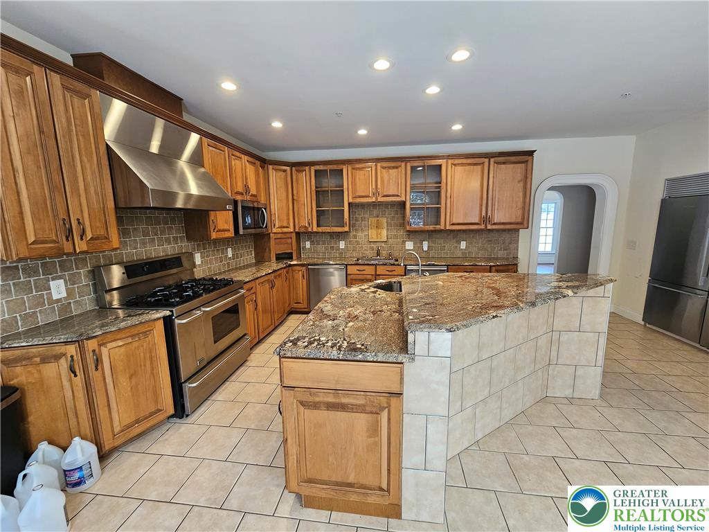 1 Dunminning Road Newtown Square, PA 19073 - Photo 7 of 30 a kitchen with stainless steel appliances granite countertop a stove top oven a sink a counter top space and cabinets