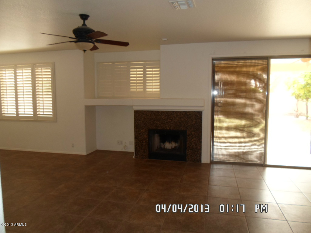 4047 East Agave Road Phoenix, AZ 85044 - Photo 4 of 20 a view of an empty room with a fireplace and a window
