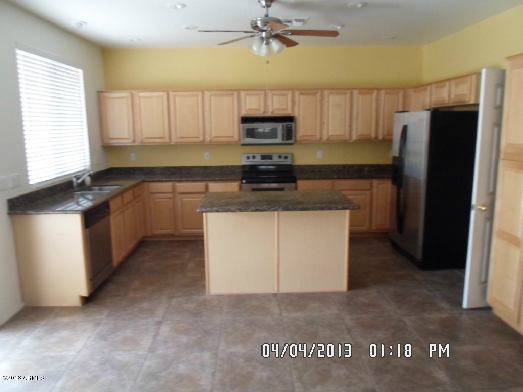 4047 East Agave Road Phoenix, AZ 85044 - Photo 5 of 20 a kitchen with stainless steel appliances granite countertop a stove a refrigerator and a microwave
