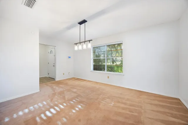 a view of a kitchen with a sink and dishwasher a refrigerator with white cabinets