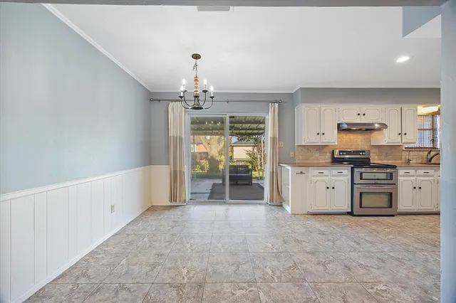 a large kitchen with white cabinets and stainless steel appliances