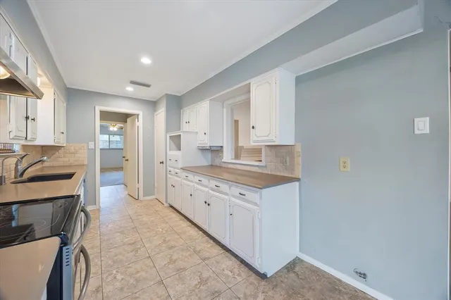 a kitchen with granite countertop a sink and cabinets