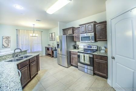 674 Red Fern Road Crestview, FL 32536 - Photo 6 of 23 a kitchen with stainless steel appliances granite countertop a stove refrigerator and cabinets