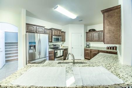 674 Red Fern Road Crestview, FL 32536 - Photo 7 of 23 a kitchen with stainless steel appliances kitchen island granite countertop a refrigerator and a sink