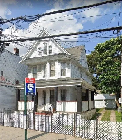 a front view of a house with glass windows and stairs