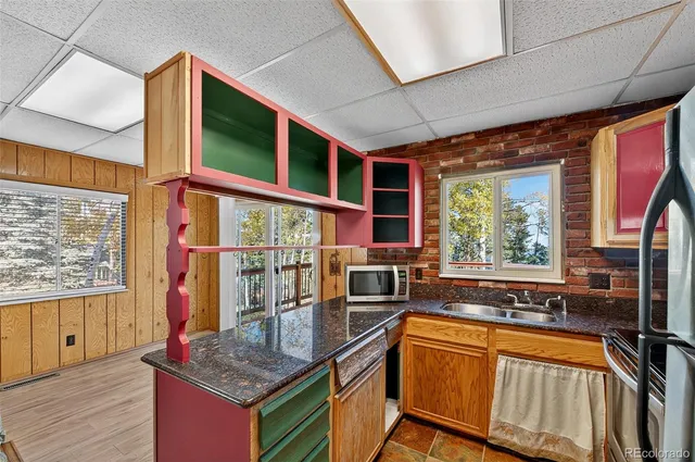 a kitchen that has a lot of cabinets and wooden floor