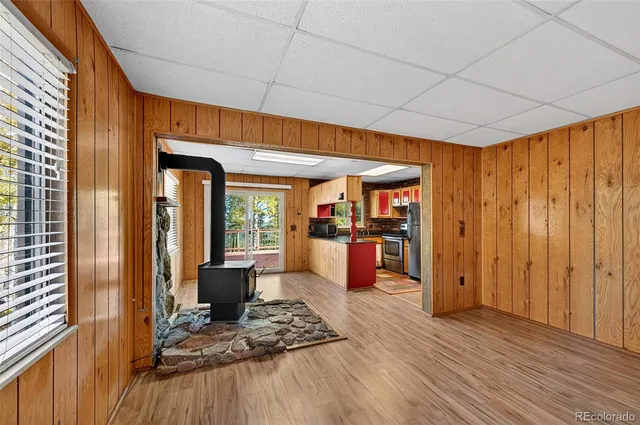 a dining hall with couches a flat tv screen and wooden floor