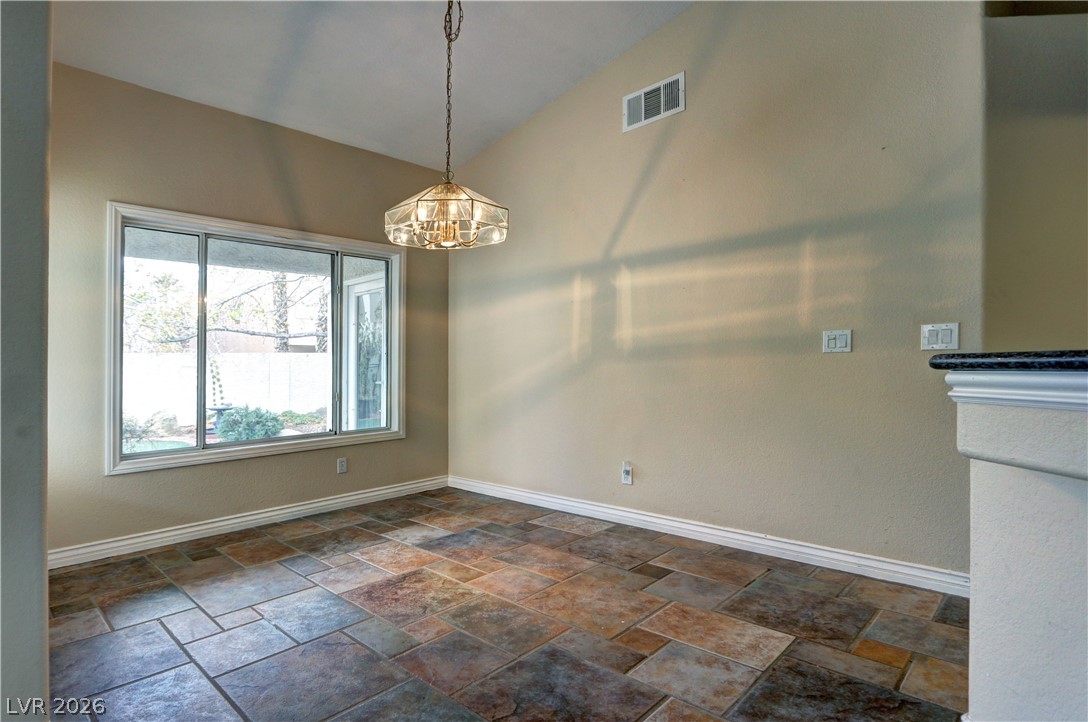 2108 Crestpoint Way Las Vegas, NV 89134 - Photo 12 of 27 A striking overhead light fixture illuminates a spacious area with unique tile flooring and a view of the outdoors.