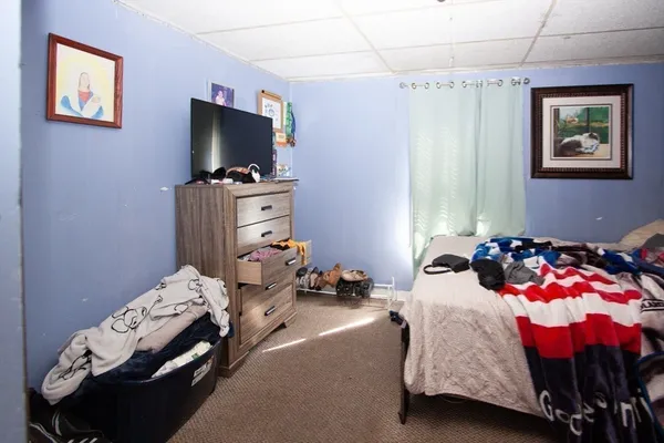 a bedroom with bed and a flat screen tv