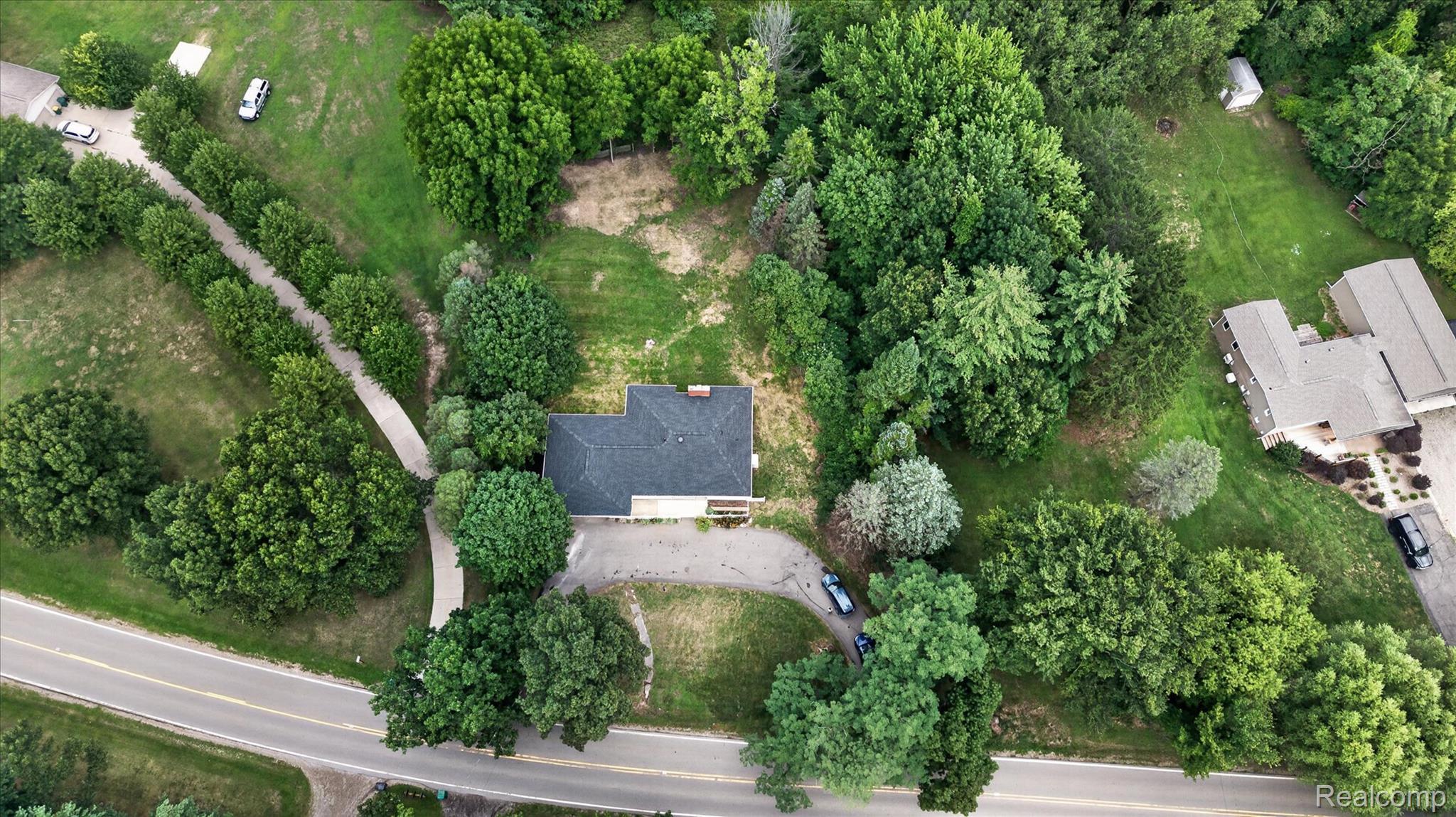 11403 White Lake Road Fenton, MI 48430 - Photo 33 of 36 Expansive lot featuring mature trees, a private driveway, and a shingle roof residence