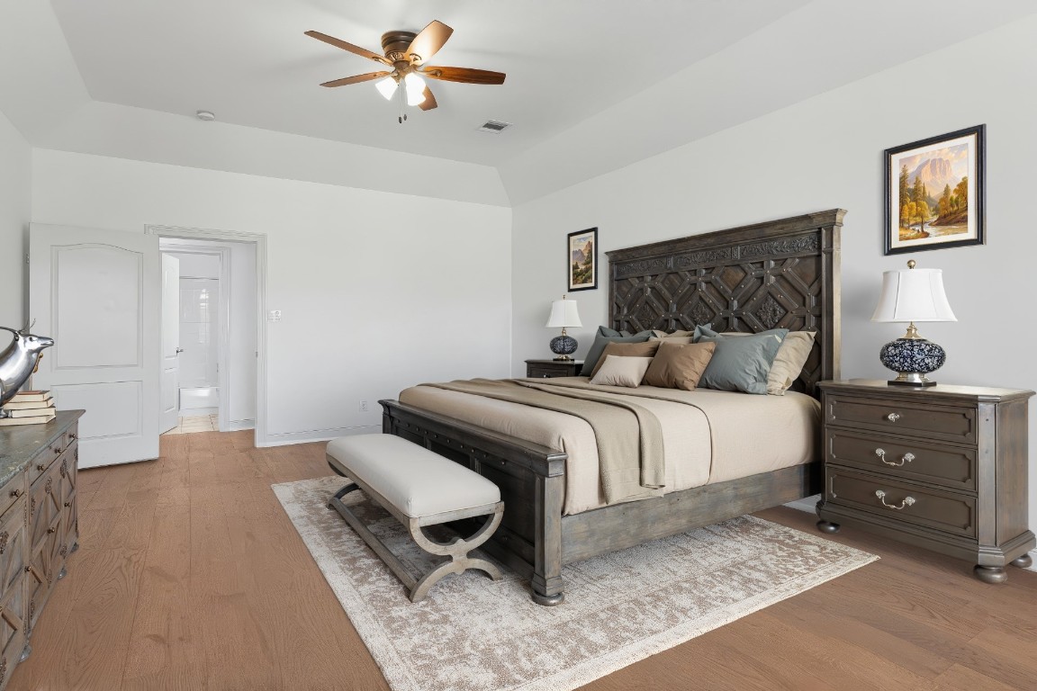 18408 West Rim Drive Jonestown, TX 78645 - Photo 16 of 30 a bedroom with a bed and a chandelier