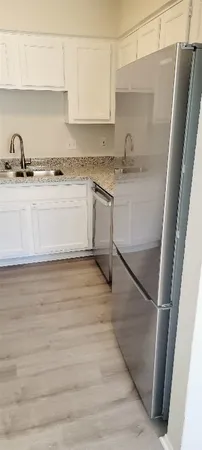a kitchen with a sink a refrigerator and cabinets
