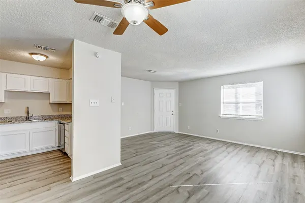 a view of a kitchen with a sink and dishwasher a refrigerator with wooden floor