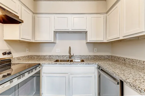 a kitchen with stainless steel appliances granite countertop a sink stove and cabinets