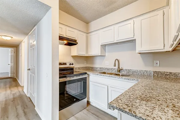 a kitchen with stainless steel appliances granite countertop a sink stove and cabinets
