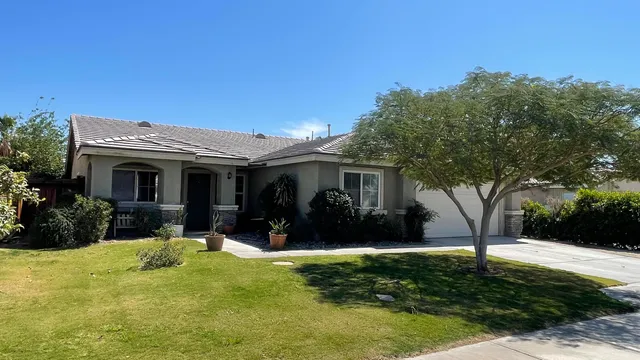 a view of a house with backyard and sitting area