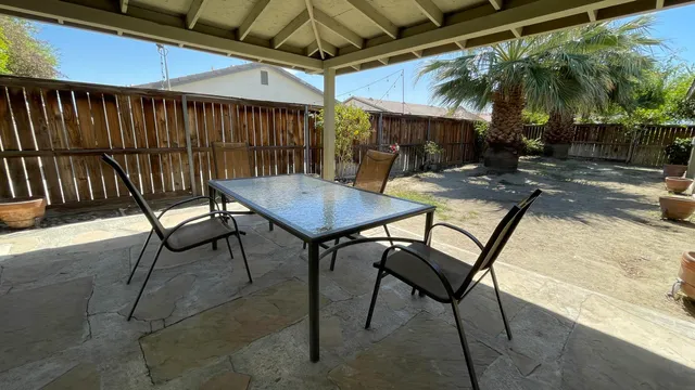a backyard of a house with table and chairs