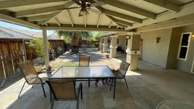 a view of a patio with table and chairs under an umbrella