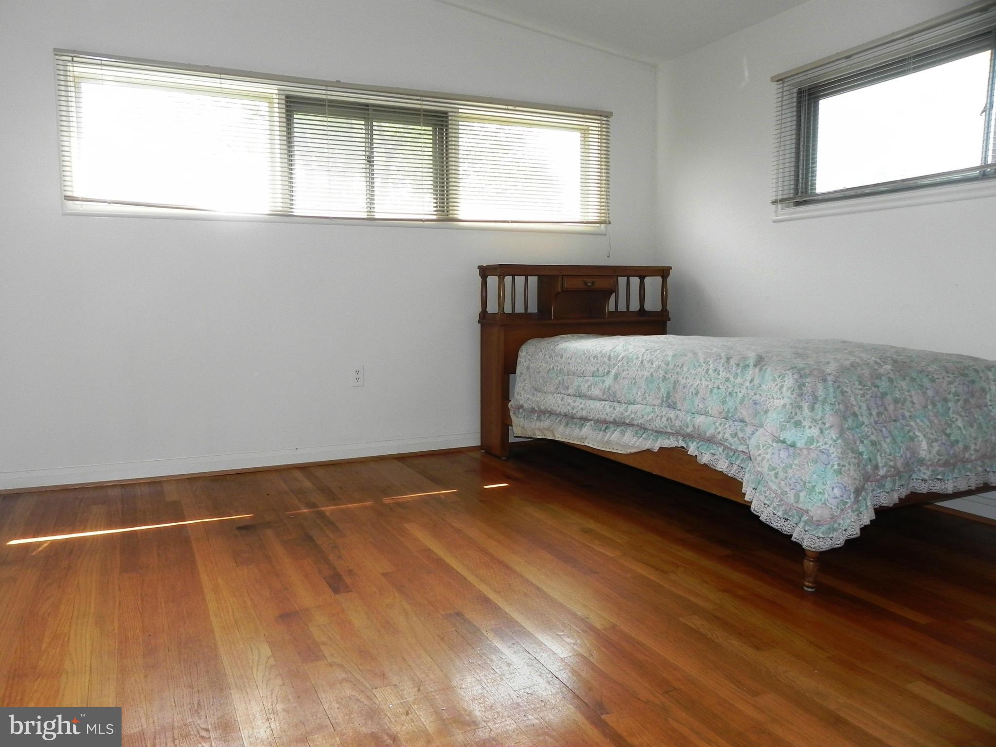 7420 Monita Road Baltimore, MD 21208 - Photo 14 of 24 a bedroom with a bed and wooden floor