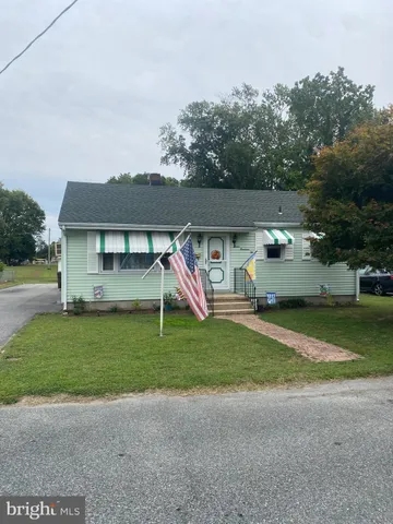 a view of a house with a yard and a car parked