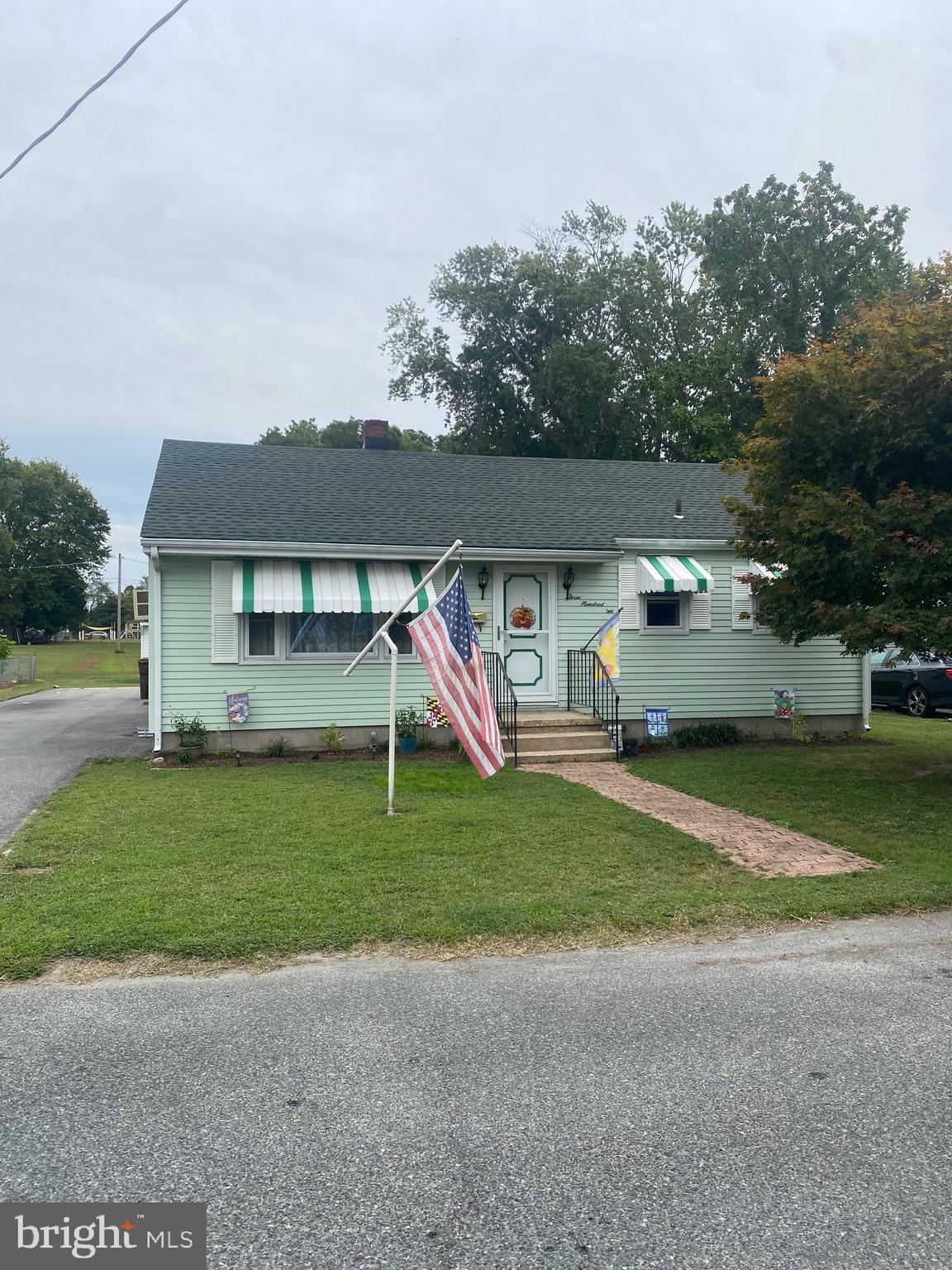 a view of a house with a yard and a car parked