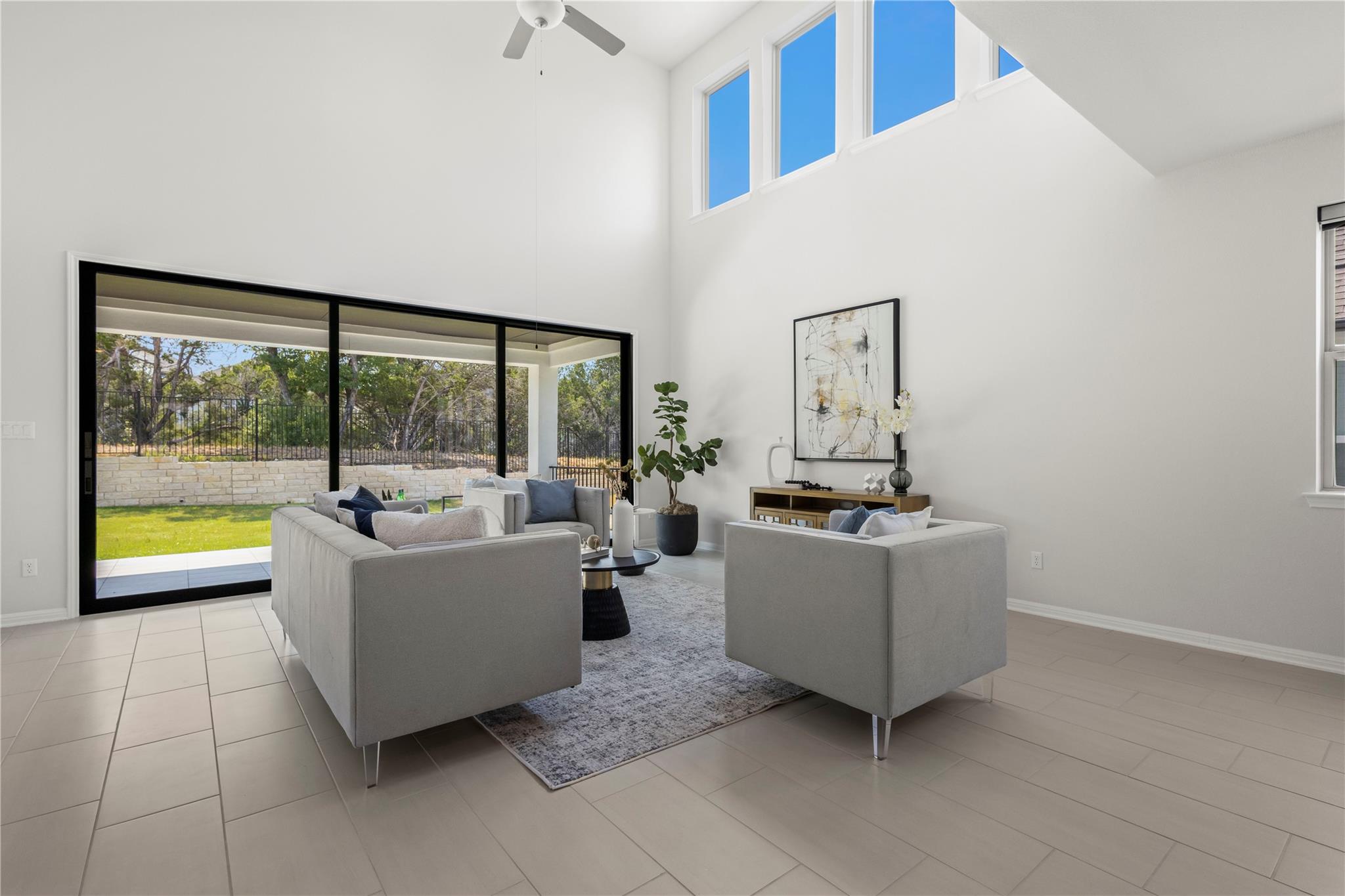 1128 Villa Rialto View Leander, TX 78641 - Photo 5 of 40 A lofty living space features high ceilings and a wide sliding door to the outdoor covered patio.