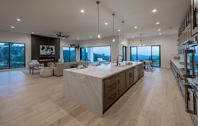 a large kitchen with stainless steel appliances kitchen island a large counter top a stove a sink and a refrigerator