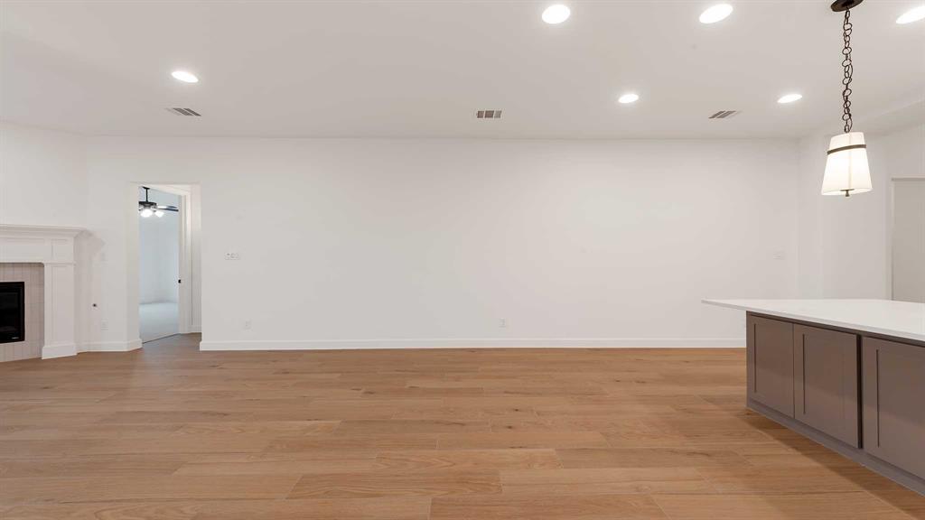 829 Stoney Bridge Way Lavon, TX 75166 - Photo 9 of 35 a view of an empty room with wooden floor and a fireplace