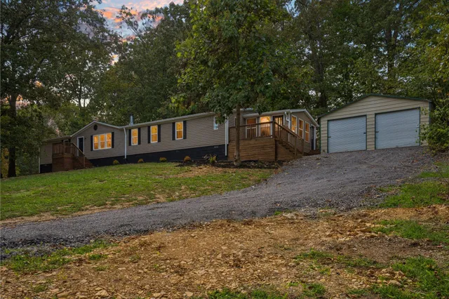 a view of a house with backyard and trees