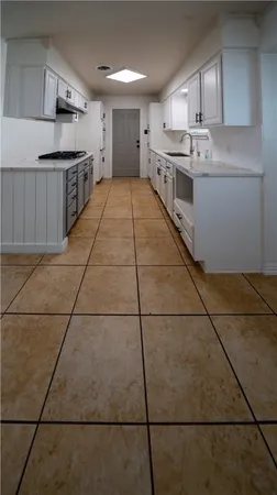 a large kitchen with a stove top oven and cabinets