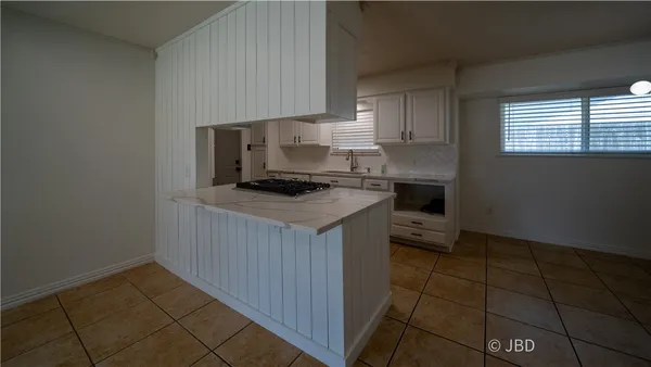 a kitchen with a sink a stove cabinets and a window