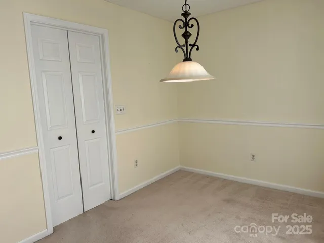 a view of room with a chandelier fan and refrigerator