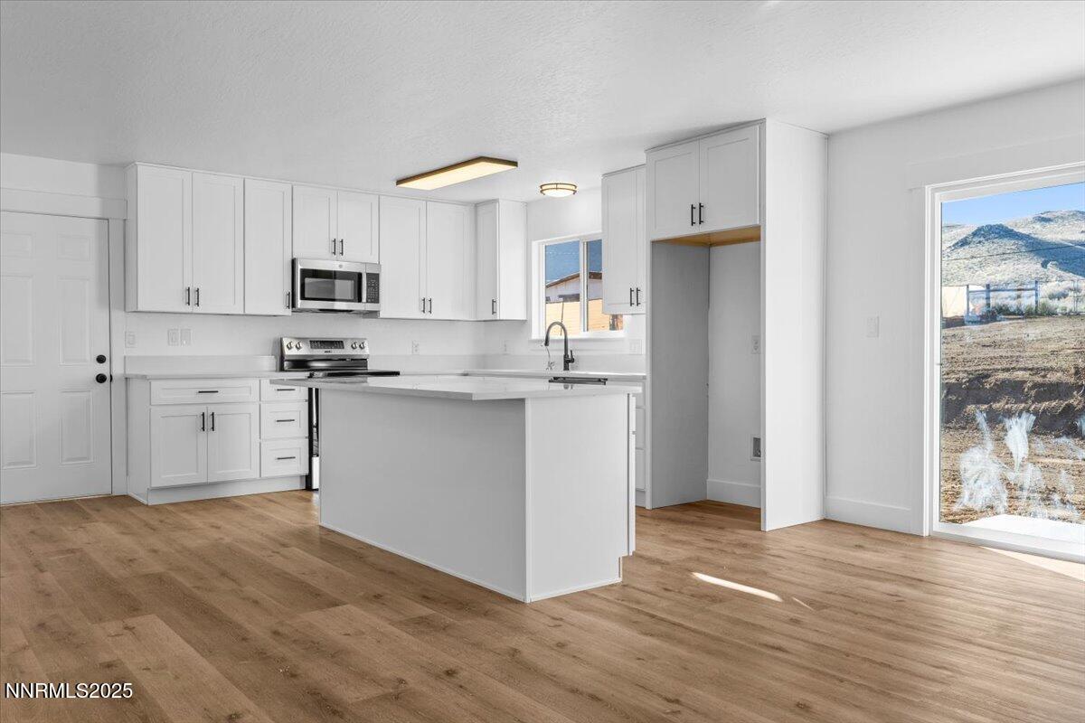 10655 Silver Spur Drive Reno, NV 89508 - Photo 7 of 34 a kitchen with stainless steel appliances granite countertop a refrigerator sink and white cabinets
