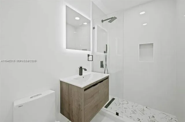 a bathroom with a sink a toilet and a mirror