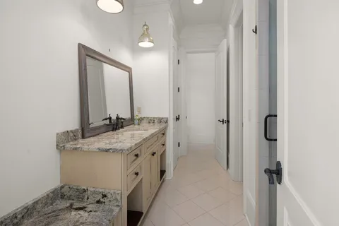 a bathroom with a granite countertop sink and a toilet