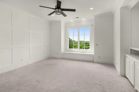 a front view of a house with a garden and trees