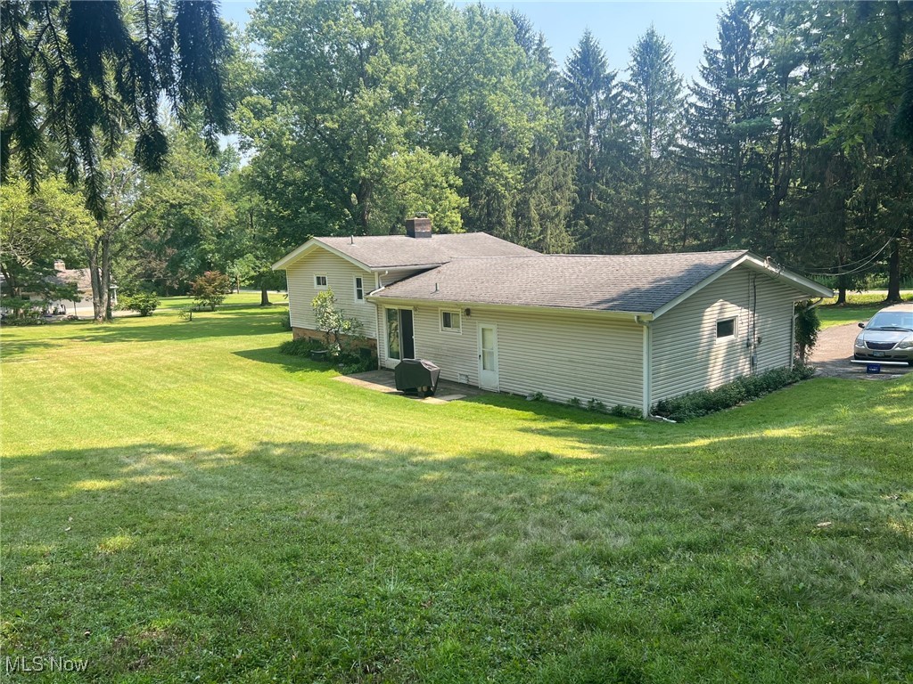 10504 Mulberry Road Chardon, OH 44024 - Photo 5 of 23 Rear view of house with a yard, patio area, and roof with shingles