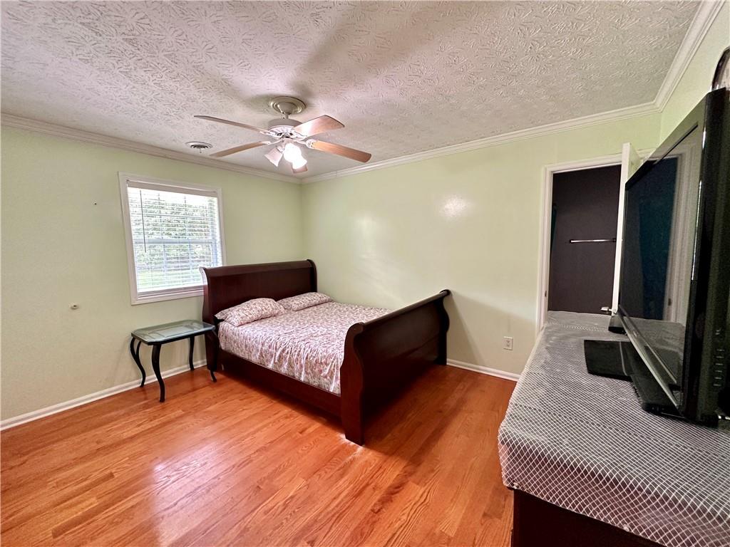 7326 Leland Lane Jonesboro, GA 30236 - Photo 12 of 18 a bedroom with a bed lamps and wooden floor