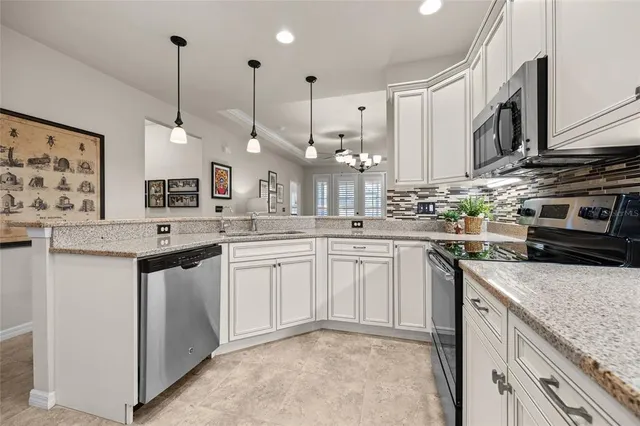 a kitchen with stainless steel appliances granite countertop a sink a stove and a wooden floors