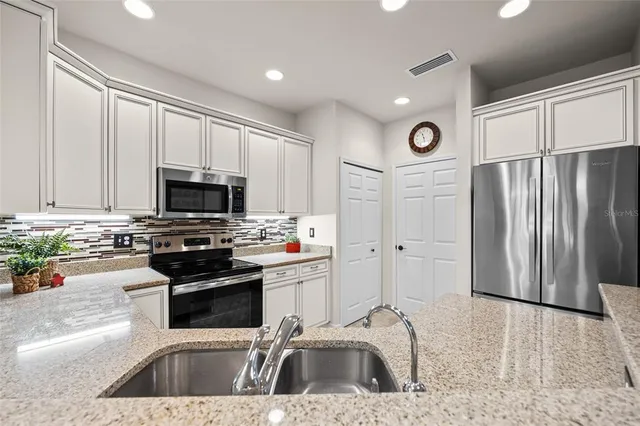 a kitchen with stainless steel appliances a refrigerator sink and microwave