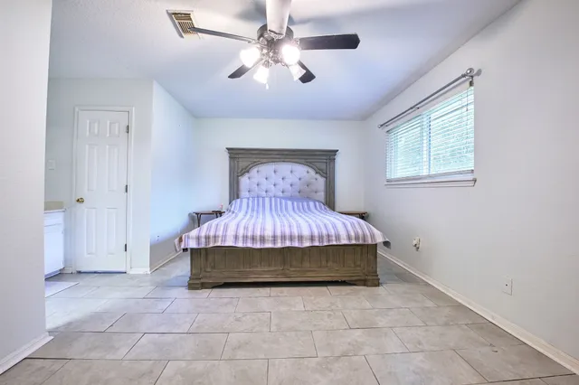 a room with a bed and a chandelier fan