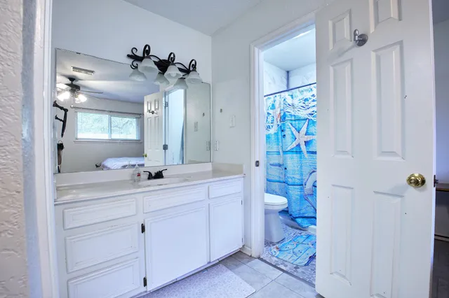 a bathroom with a double vanity sink toilet and shower